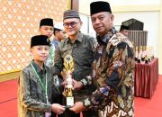 Bupati Oskar Manoppo saat menyerahkan piala kepada salah satu Peserta asal Boltim