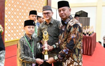 Bupati Oskar Manoppo saat menyerahkan piala kepada salah satu Peserta asal Boltim