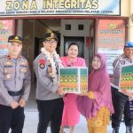 Kapolres Boltim AKBP Golfrid Hasiholan Pakpahan bersama Ketua Bhayangkari Cabang Boltim, Ny. Joice Golfrid, menyerahkan bantuan kepada warga dalam rangka kunjungan kerja di Polsek Nuangan. Kegiatan ini sekaligus menegaskan komitmen Polri menjaga integritas, pelayanan publik, dan mendukung program ketahanan pangan melalui Pekarangan Pangan Lestari (P2L).