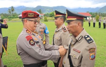 Kapolres AKBP Golfried Hasiholan memimpin prosesi penyematan tanda jabatan kepada pejabat baru. Kegiatan berlangsung di Lapangan Apel Polres Boltim dengan dihadiri pejabat utama, personel, dan Bhayangkari.