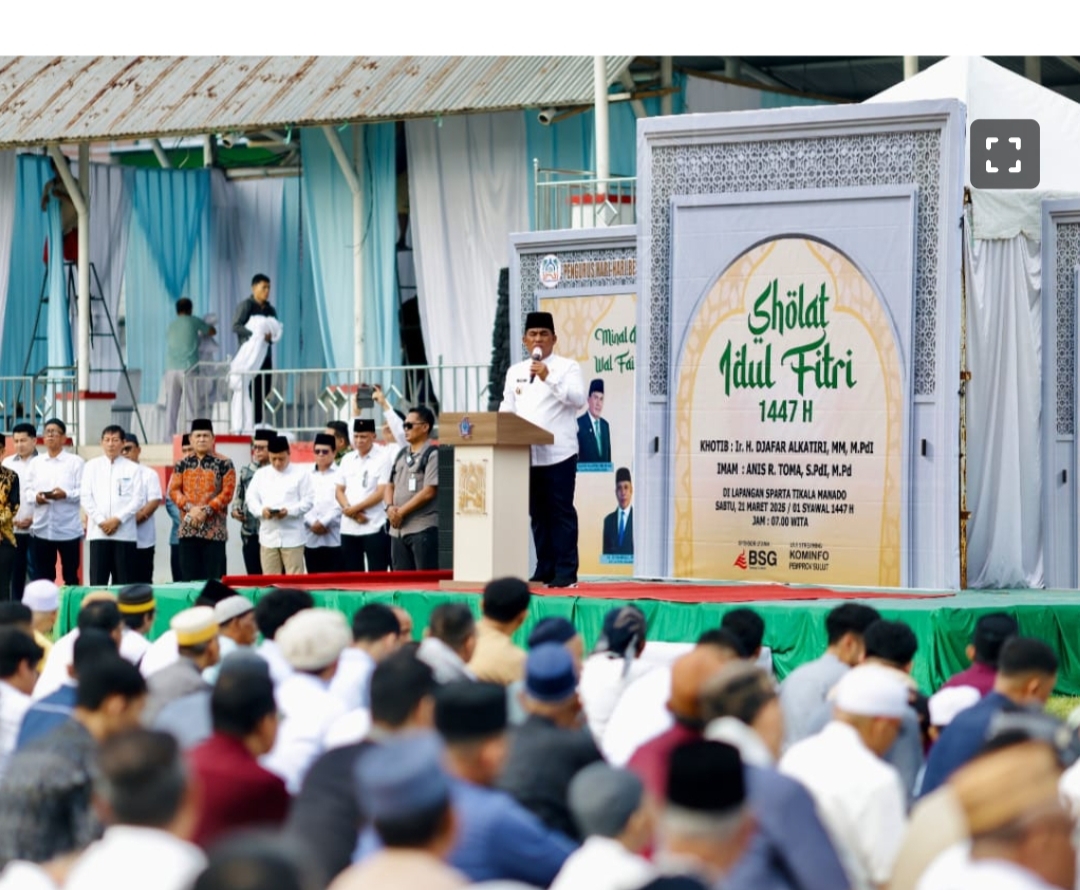 Gubernur Sulawesi Utara, Mayjen TNI (Purn) Yulius Selvanus (YSK), saat memberikan sambutan khusus di hadapan ribuan jamaah Sholat Idul Fitri 1447 Hijriah di Lapangan Tikala, Manado, Sabtu (21/03/2026). Dalam pesannya, Gubernur menekankan pentingnya menjaga persatuan dan menjadikan spirit Idul Fitri sebagai pondasi pembangunan daerah yang rukun dan maju. Di belakangnya tampak backdrop panggung yang memuat informasi detil mengenai pelaksanaan sholat, termasuk nama Khatib dan Imam. Di area panggung samping juga terlihat Gubernur yang didampingi pejabat Pemkot Manado.Foto: Diskominfo Pemprov Sulut.