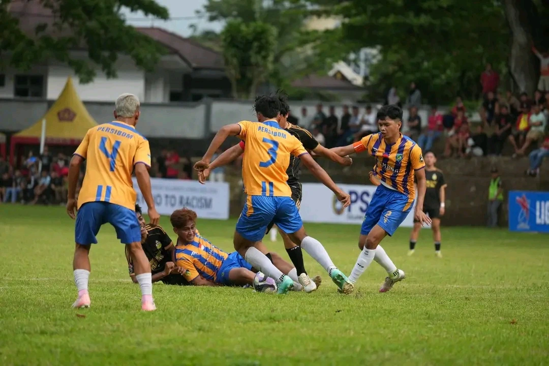 Aksi pemain Persibom saat berebut bola dengan tim lawan dalam laga Liga 4 Sulut. Pertandingan berlangsung sengit di lapangan hijau dengan dukungan penonton dari pinggir lapangan. Spanduk bertuliskan “Say No to Racism” turut menghiasi arena, menegaskan semangat sportivitas dan persatuan di tengah rivalitas kompetisi.
