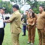 Gubernur Yulius Selvanus menyerahkan tanda orientasi kepada peserta PPPK dalam apel besar di halaman Kantor Gubernur Sulut, Selasa (28/4/2026). (Dokumentasi Humas Pemprov Sulut)