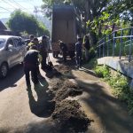 GERAK CEPAT: Sejumlah personel Bidang Bina Marga Dinas PUPR Kota Kotamobagu bergotong-royong membersihkan material endapan tanah dan sedimentasi di ruas Jalan Arief Rahman Hakim, tepatnya di kompleks GOR Ambang, Kotamobagu.