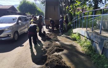 GERAK CEPAT: Sejumlah personel Bidang Bina Marga Dinas PUPR Kota Kotamobagu bergotong-royong membersihkan material endapan tanah dan sedimentasi di ruas Jalan Arief Rahman Hakim, tepatnya di kompleks GOR Ambang, Kotamobagu.