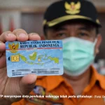 Petugas Dukcapil menunjukkan e-KTP dengan chip elektronik.