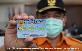 Petugas Dukcapil menunjukkan e-KTP dengan chip elektronik.