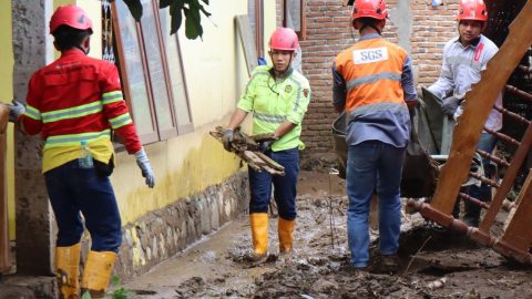 Tim JRBM bersama aparat dan relawan bergotong royong membersihkan material lumpur pasca banjir bandang di Desa Solimandungan, Bolmong. Foto: Humas JRBM