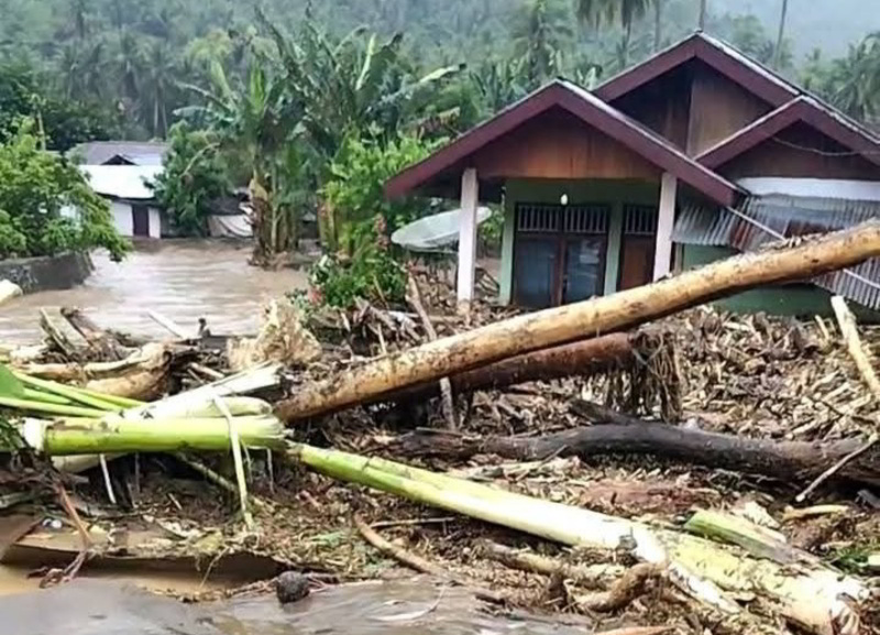 Material kayu dan lumpur menutup akses jalan serta merendam rumah warga di Desa Solimandungan, Kecamatan Bolaang, Kabupaten Bolmong, Selasa (27/5/2026).