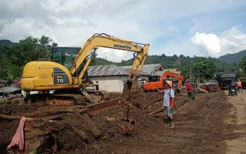 Sangadi Solimandungan Dua, Bebi Balongka, meninjau proses pembersihan material lumpur pascabanjir bandang di desanya bersama petugas gabungan menggunakan alat berat Komatsu PC70.