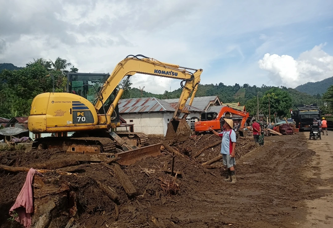 Sangadi Solimandungan Dua, Bebi Balongka, meninjau proses pembersihan material lumpur pascabanjir bandang di desanya bersama petugas gabungan menggunakan alat berat Komatsu PC70.