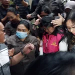 DITETAPKAN SEBAGAI TERSANGKA: Bupati Sitaro, Chyntia Kalangit (tengah), mengenakan rompi merah muda saat digiring petugas menuju mobil tahanan di kantor Kejati Sulawesi Utara, Manado, Rabu (6/5/2026). Chyntia ditetapkan sebagai tersangka kelima dalam kasus dugaan korupsi dana bantuan bencana Gunung Ruang.