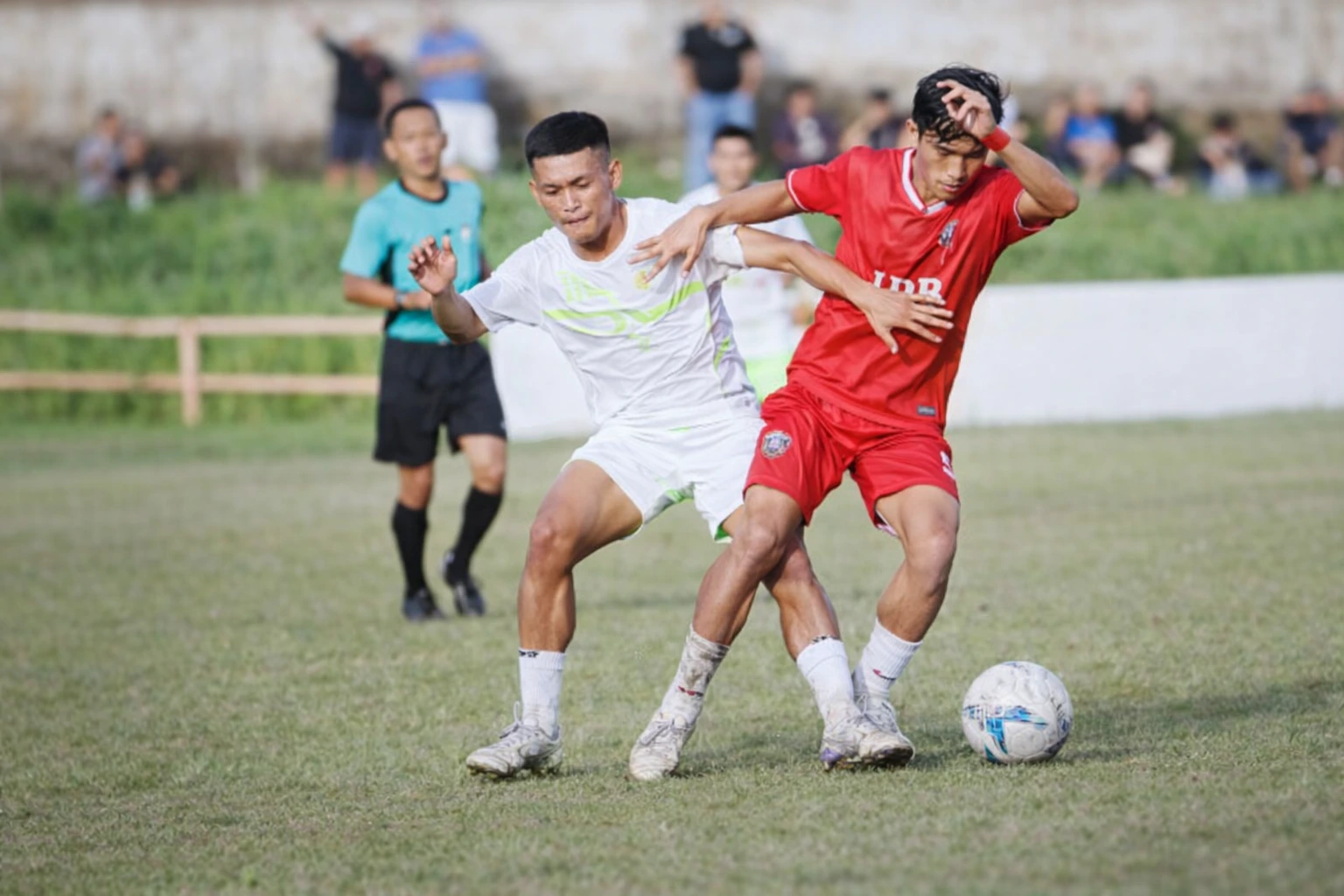 Pemain Amkei Kodim 1303 Bolmong dan Bonawang FC terlibat perebutan bola dalam laga bertensi tinggi pada lanjutan Matali Cup V di Lapangan Nunuk Matali, Rabu (13/5/2026). Pertandingan berakhir imbang 2-2.
