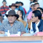 Gubernur Yulius Selvanus, mengenakan topi, tampak serius menonton jalannya Kejuaraan Pacuan Kuda Piala Gubernur 2026 di Tompaso, sembari menegaskan komitmen menjadikan Maesa Tompaso sebagai pusat olahraga berkuda nasional.