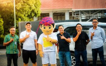Ketua Askot PSSI Kotamobagu dengan kaos putih berdiri di samping maskot resmi Totabuan Champions League (TCL) 2026. Di sisi kanan, Wali Kota Kotamobagu dr. Weny Gaib mengenakan kaos hitam, bersama-sama menunjukkan dukungan atas peluncuran maskot “Bojo” yang akan memeriahkan turnamen di Stadion Nunuk Matali.