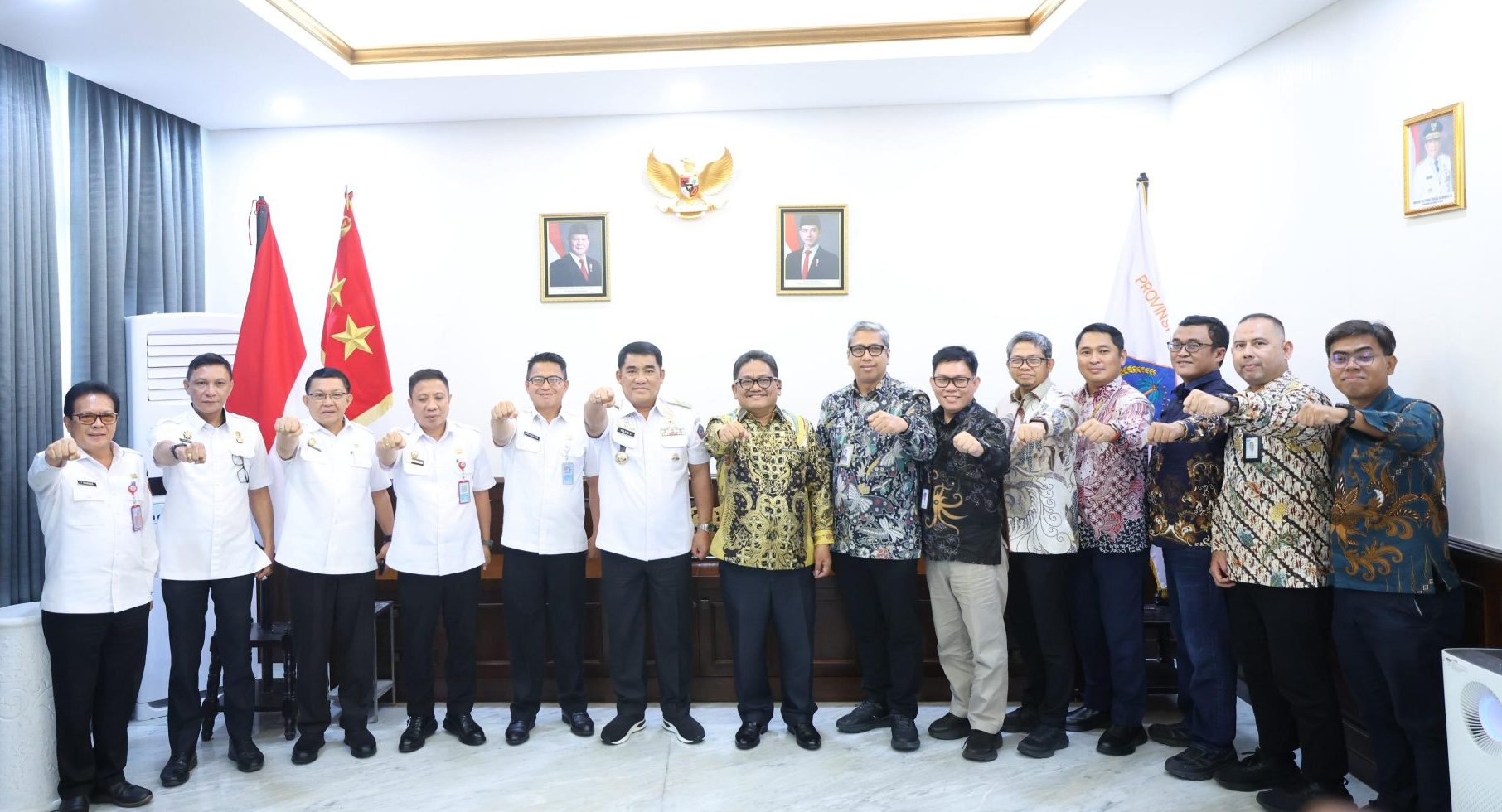 Gubernur Yulius Selvanus (tengah, kemeja putih tanda jasa) melakukan salam komando bersama manajemen PLN UID Suluttenggo dan jajaran Pemprov Sulut setelah menyepakati komitmen bersama untuk mengebut proyek infrastruktur ketenagalistrikan perdesaan dan kepulauan terluar, Rabu (3/6/2026). Foto: Humas Pemprov Sulut