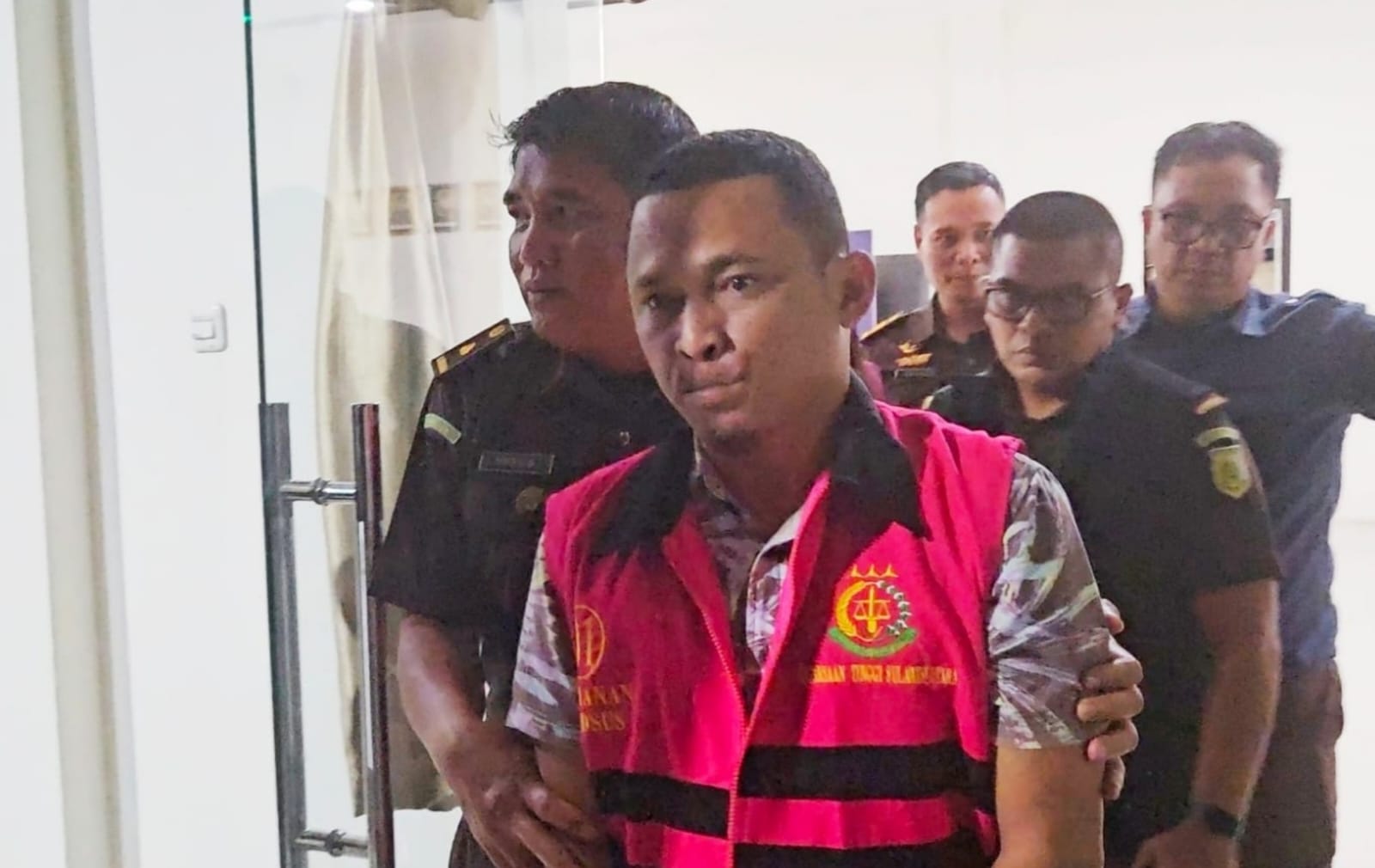 Eks Bendahara Pengeluaran KPU Boltim, Arga Karian, resmi mengenakan rompi tahanan Kejari Kotamobagu usai ditetapkan tersangka kasus korupsi dana rutin tahun 2021.