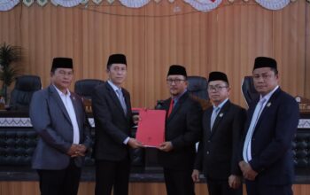 Bupati Iskandar Kamaru bersama Wakil Bupati Deddy Abdul Hamid menyerahkan dokumen Ranperda Pertanggungjawaban Pelaksanaan APBD 2025 kepada pimpinan DPRD Bolsel dalam Rapat Paripurna di Panango, Rabu (17/6/2026).