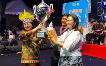 Ibu Anik Wandriani menerima langsung Piala Presiden RI sebagai simbol kemenangan Juara Umum Pesparawi Nasional bagi kontingen Sulawesi Utara di Manokwari, Papua.