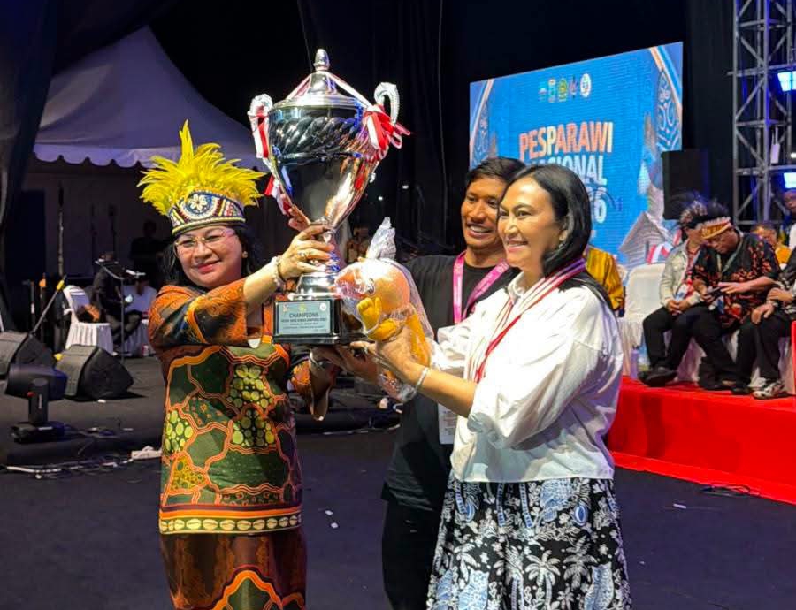 Ibu Anik Wandriani menerima langsung Piala Presiden RI sebagai simbol kemenangan Juara Umum Pesparawi Nasional bagi kontingen Sulawesi Utara di Manokwari, Papua.