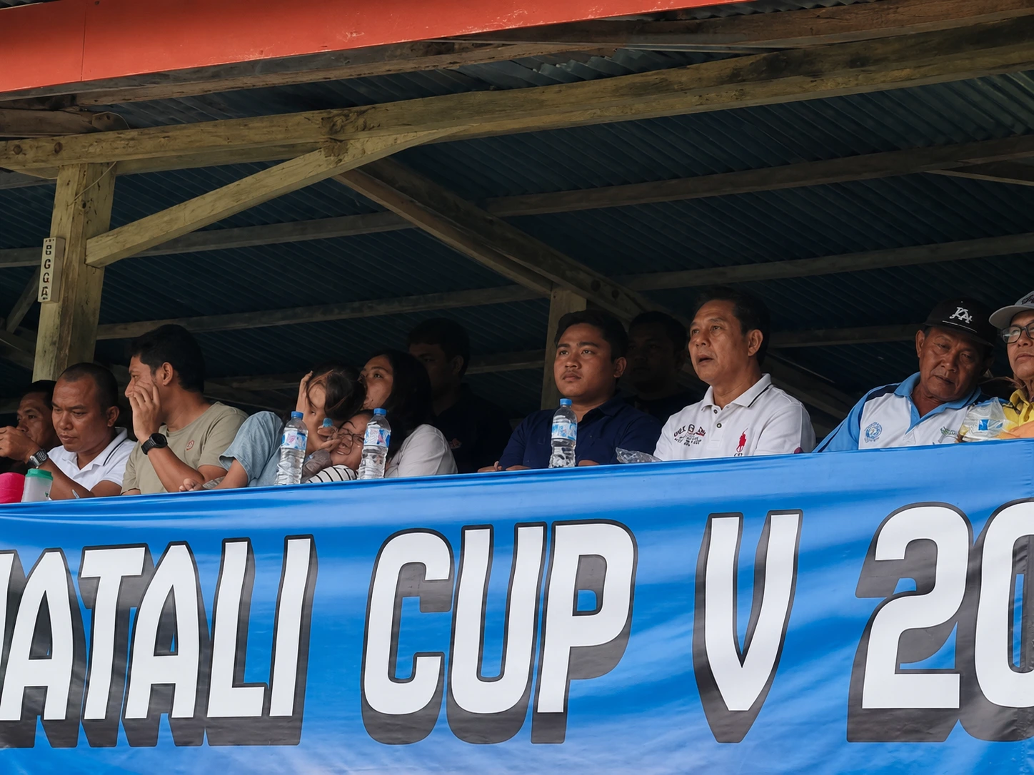 Kasat Reskrim Polres Kotamobagu Ahmad Waafi mengenakan kemeja blue navy saat mengawal langsung jalannya semifinal Liga Amatir PSSI di Stadion Nunuk Matani, memastikan laga berlangsung aman, tertib, dan penuh sportivitas.