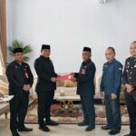 Wabup Bolsel Deddy Abdul Hamid menyerahkan SK Plt. Kasatpol PP kepada Marwan Makalalag dalam prosesi resmi yang disaksikan jajaran pemerintah daerah.