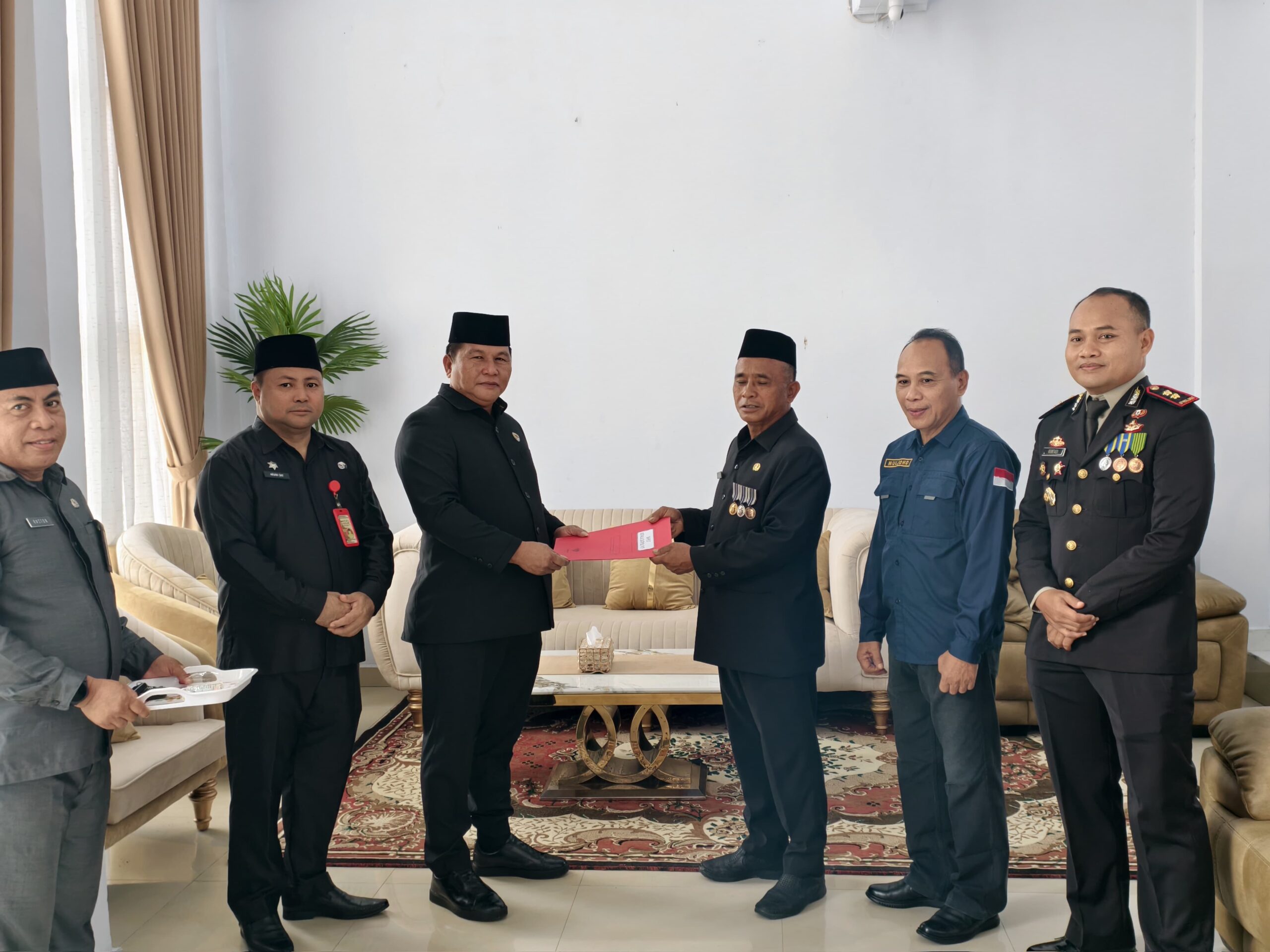 Wabup Bolsel Deddy Abdul Hamid menyerahkan SK Plt. Kasatpol PP kepada Marwan Makalalag dalam prosesi resmi yang disaksikan jajaran pemerintah daerah.
