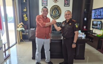 Kajari Kotamobagu Tasjrifin M. A. Halim, S.H., M.H. (kanan) berjabat tangan dengan Ketua PWI Kotamobagu terpilih Koni Balamba (kiri) saat audiensi di ruang kerja Kejaksaan Negeri Kotamobagu, Rabu (1/7/2026).