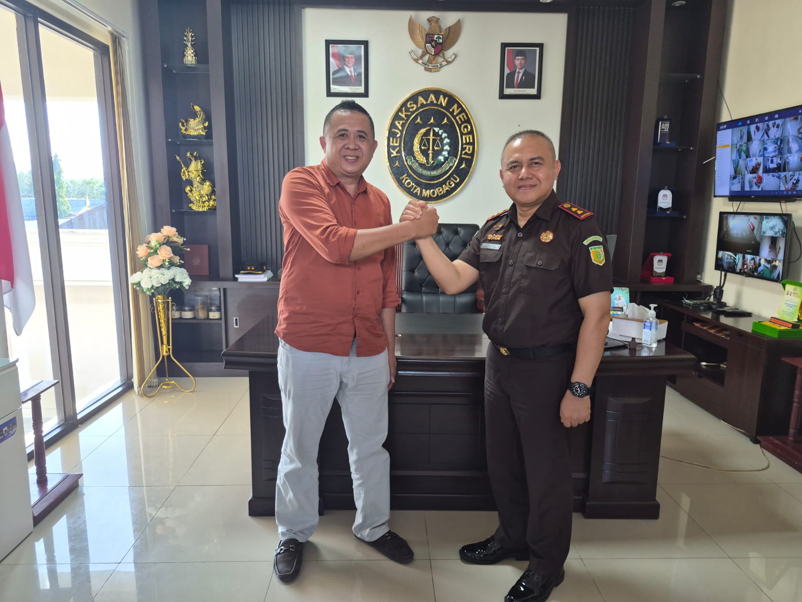 Kajari Kotamobagu Tasjrifin M. A. Halim, S.H., M.H. (kanan) berjabat tangan dengan Ketua PWI Kotamobagu terpilih Koni Balamba (kiri) saat audiensi di ruang kerja Kejaksaan Negeri Kotamobagu, Rabu (1/7/2026).