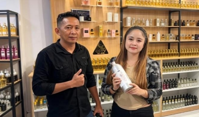 Pemilik Mandiri Parfum Kotamobagu, Winda Lompu dan Mahmud Nawir, saat melayani pelanggan di toko baru mereka yang terletak di Kelurahan Matali, Kotamobagu Timur.