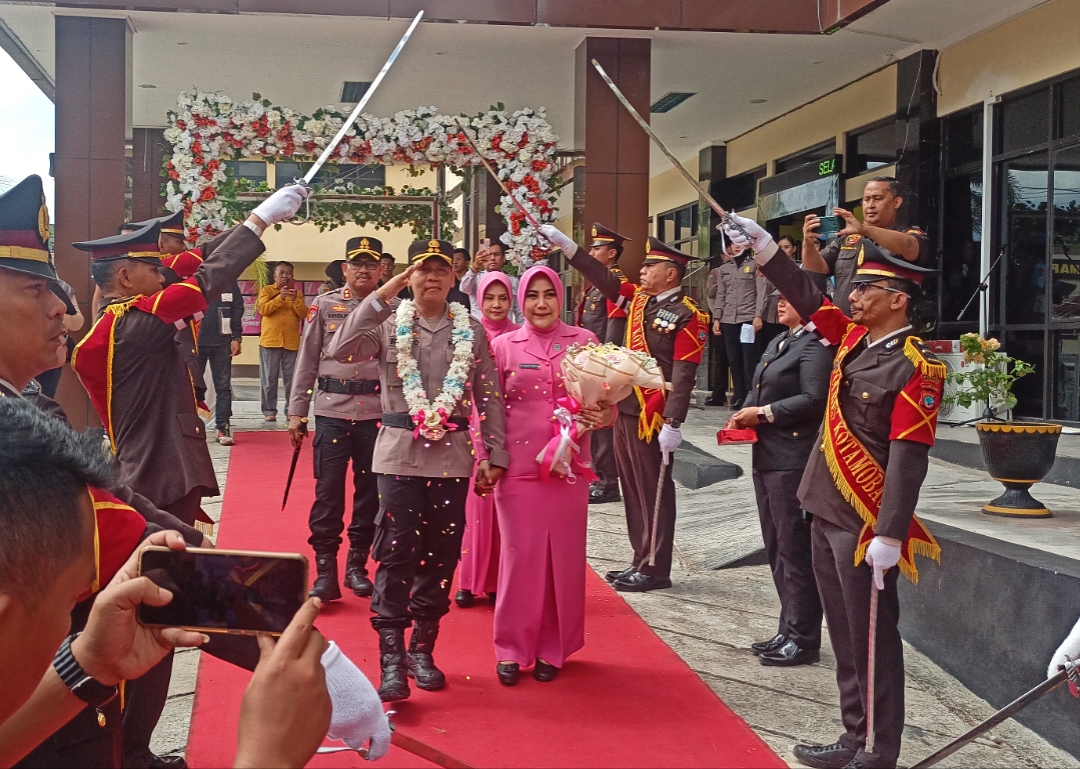 Kapolres Kotamobagu yang baru AKBP Abdul Kholik mendampingi AKBP Irwanto beserta istri dalam prosesi tradisi Pedang Pora di halaman Mapolres Kotamobagu, Senin, 13 Juli 2026. Foto: Sulutplus