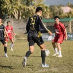 Aksi pemain Burako Alason FC, Risky, saat mencoba melewati penjagaan ketat bek Bonawang FC, Rigel, pada laga lanjutan Grup A Totabuan Champions League 2026 di Stadion Nunuk Matali. Laga sengit sore itu berakhir dengan kemenangan telak Burako Alason FC 7-0.