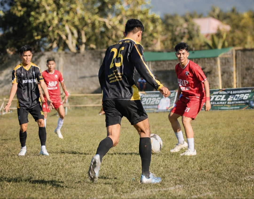 Aksi pemain Burako Alason FC, Risky, saat mencoba melewati penjagaan ketat bek Bonawang FC, Rigel, pada laga lanjutan Grup A Totabuan Champions League 2026 di Stadion Nunuk Matali. Laga sengit sore itu berakhir dengan kemenangan telak Burako Alason FC 7-0.