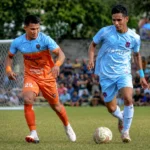 Pemain Bintang Muda Matali (jersey biru langit) mencoba menguasai bola di bawah pengawalan ketat pemain ZM FC Bolsel (jersey oranye) pada laga final Totabuan Champions League (TCL) 2026 di Lapangan Nunuk, Kotamobagu, Minggu (9/8/2026).